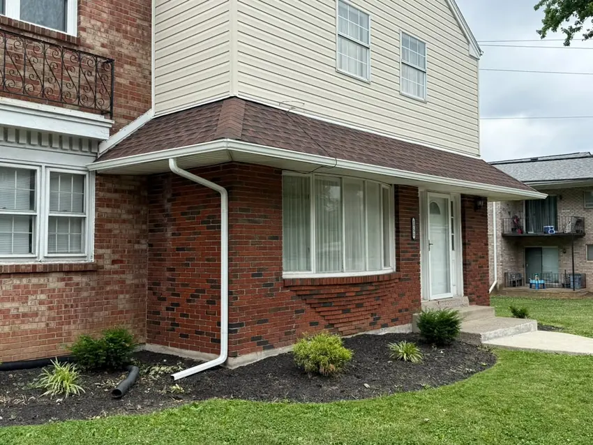 White gutters and downspouts on a brick home