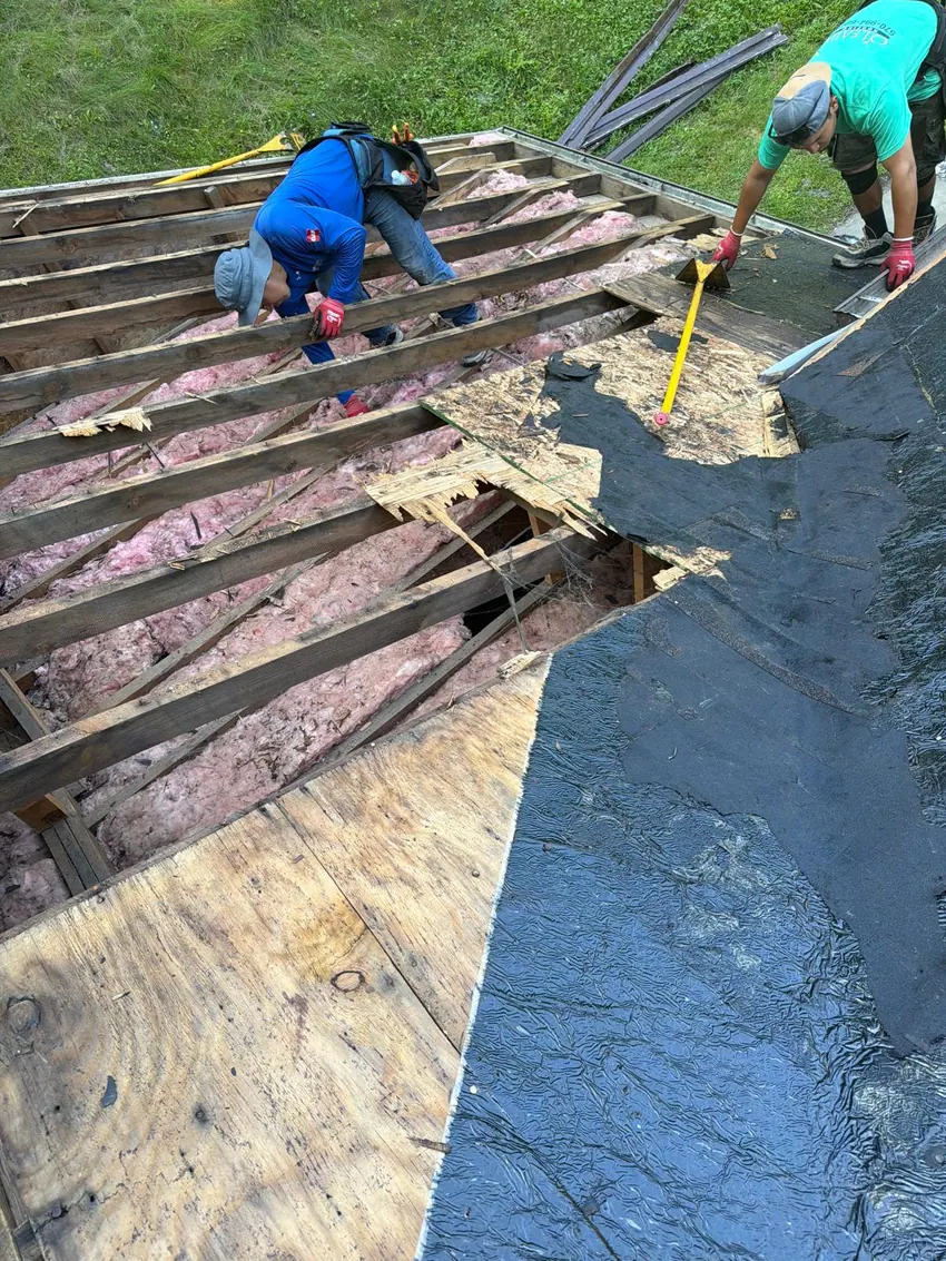 Roof repair crew inspecting and replacing decking