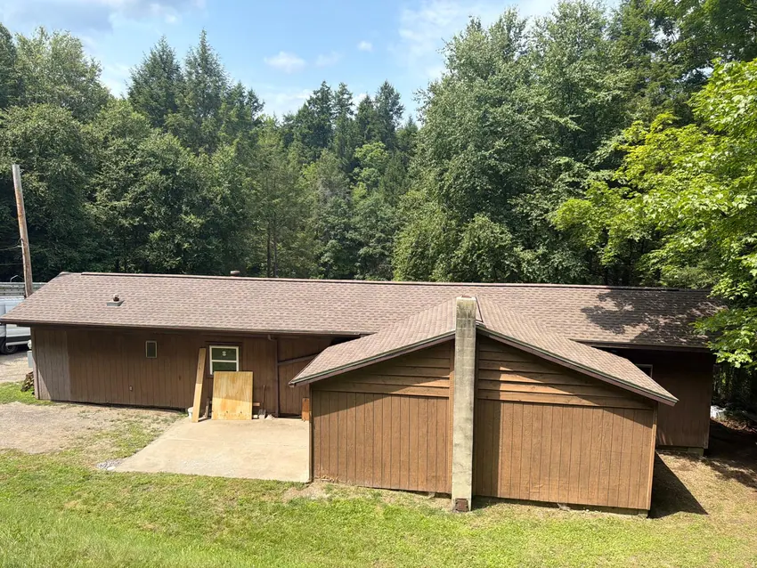 Residential shingle roof in a wooded setting
